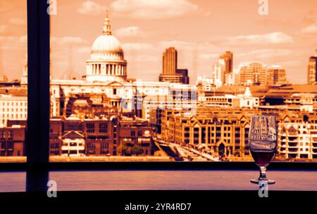 Un verre de bière et une vue depuis le café de la galerie Tate Modern sur la cathédrale Saint-Paul avec le pont du Millénaire sur la Tamise. Londres, Angleterre. Réflexions Banque D'Images