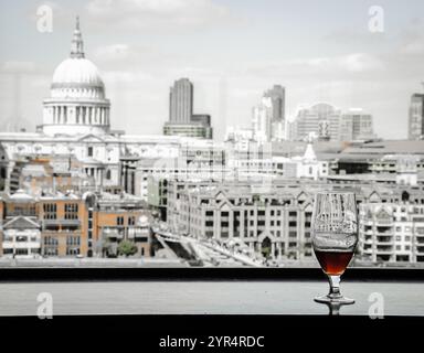 Un verre de bière et une vue depuis le café de la galerie Tate Modern sur la cathédrale Saint-Paul avec le pont du Millénaire sur la Tamise. Londres, Angleterre. Réflexions Banque D'Images