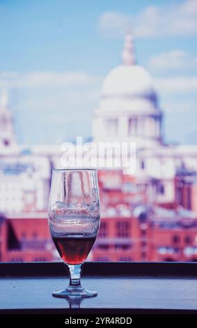 Un verre de bière et une vue depuis le café de la galerie Tate Modern sur la cathédrale Saint-Paul. Londres, Angleterre. Photo tonifiée. Banque D'Images