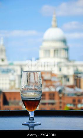 Un verre de bière et une vue depuis le café de la galerie Tate Modern sur la cathédrale Saint-Paul. Londres, Angleterre. Banque D'Images