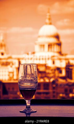 Un verre de bière et une vue depuis le café de la galerie Tate Modern sur la cathédrale Saint-Paul. Londres, Angleterre. Photo tonifiée. Banque D'Images