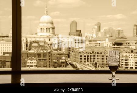 Un verre de bière et une vue depuis le café de la galerie Tate Modern sur la cathédrale Saint-Paul avec le pont du Millénaire sur la Tamise. Londres, Angleterre. Réflexions Banque D'Images