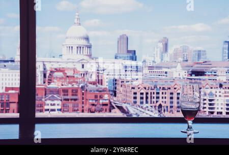 Un verre de bière et une vue depuis le café de la galerie Tate Modern sur la cathédrale Saint-Paul avec le pont du Millénaire sur la Tamise. Londres, Angleterre. Réflexions Banque D'Images