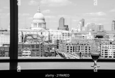 Un verre de bière et la vue depuis le café de la galerie Tate Modern sur la cathédrale Saint-Paul avec le pont du Millénaire sur la Tamise. Londres, Angleterre. Noir blanc Banque D'Images