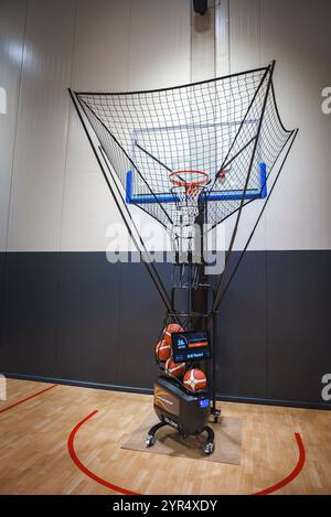 Terrain de basket-ball intérieur avec machine de tir moderne et sol poli Banque D'Images