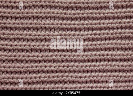 Texture classique du pull en laine tricotée. Tissu de pull tricoté rose doux avec des détails de fil confortables. Plat, vue de dessus. Banque D'Images