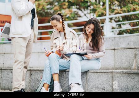 Les étudiants étudient ensemble à l'extérieur dans un cadre urbain après les cours Banque D'Images