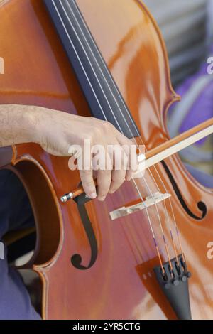 Gros plan des mains d'un homme méconnaissable jouant du violoncelle Banque D'Images