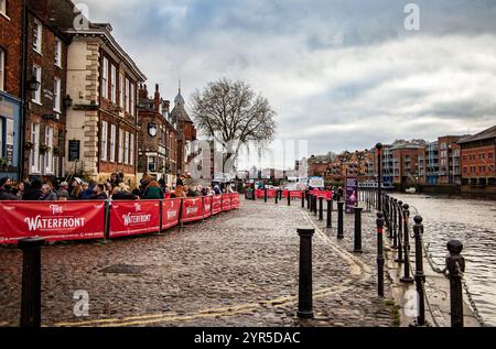 Les gens appréciant des places assises à l'extérieur au pub Waterfront le long d'une rue pavée à côté de la rivière Ouse dans la ville historique de York UK novembre 2024 Banque D'Images