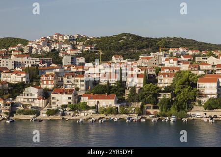 Vue en angle élevé sur les maisons et villas aux finitions brunes et blanches avec toits traditionnels en tuiles d'argile cuite sur la colline et bateaux amarrés sur la péninsule de Lapad Banque D'Images