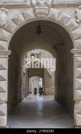 Arc en pierre au-dessus d'une étroite ruelle pavée avec des lampes anciennes et des murs de pierre historiques, centre historique d'Altamura, Pouilles, Italie, Europe Banque D'Images