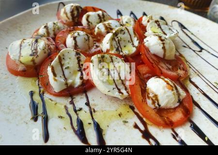 Cuisine italienne, Insalata Caprese, tomates de vigne, mozza de buffle disposés sur une assiette, vinaigre balsamique, huile d'olive, salade, restaurant italien, restauran Banque D'Images