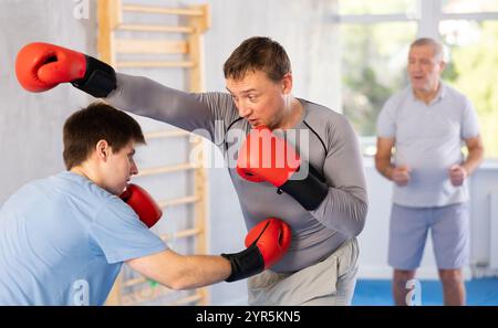 Portrait d'athlètes actifs en compétition dans des gants de boxe dans le ring de boxe Banque D'Images