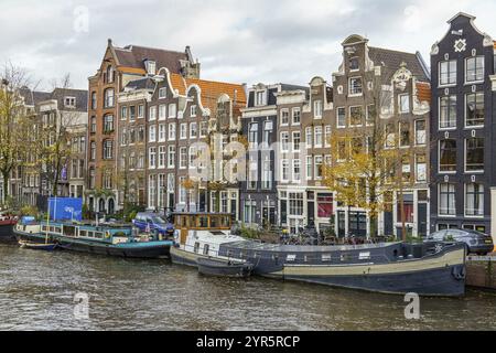 Rangée de bâtiments majestueux le long du canal comme l'automne colore les arbres, Amsterdam, pays-Bas Banque D'Images