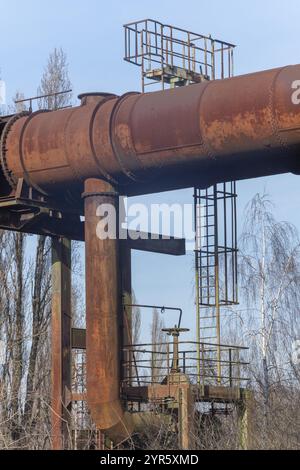 Structure de machines industrielles rouillées avec de grands tuyaux contre le ciel Banque D'Images