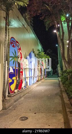 Oahu, Hawaï, États-Unis - 22 février 2022 : une passerelle bordée de planches de surf menant à la plage depuis la principale zone commerçante de Waikiki Beach Banque D'Images