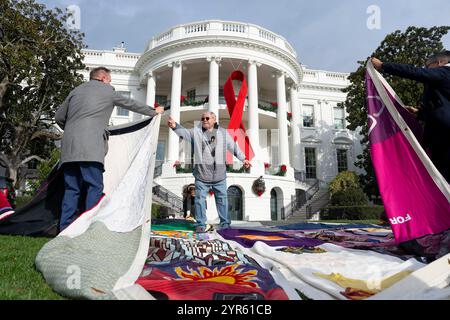 Washington, États-Unis. 1er décembre 2024. Des volontaires ont installé des sections de la courtepointe commémorative du sida sur la pelouse sud à l'occasion de la Journée mondiale du sida à la Maison Blanche, le 1er décembre 2024, à Washington, DC la courtepointe commémore les vies perdues par l'épidémie de sida et est exposée pour la première fois à la Maison Blanche. Crédit : Oliver Contreras/White House photo/Alamy Live News Banque D'Images