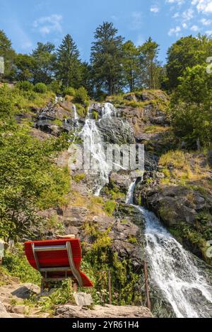 Un siège rouge sous la cascade de Todtnau dans la Forêt Noire en Allemagne Banque D'Images