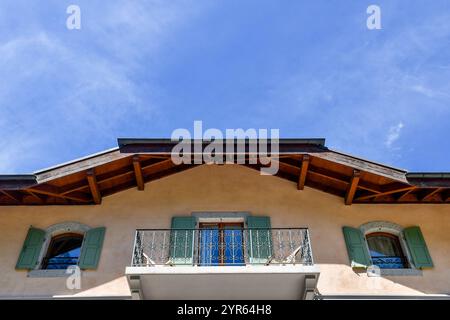 Vue en bas angle sur le grenier d'une maison de montagne avec balcon et volets vert pâle contre ciel bleu, Chamonix, France Banque D'Images