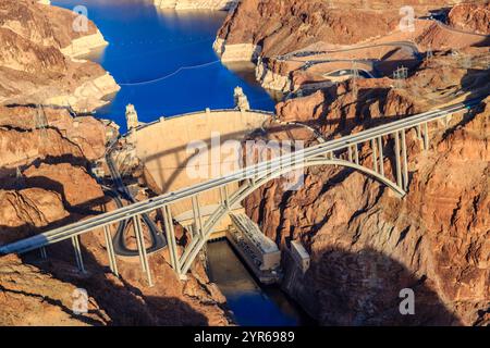 Un pont enjambe une rivière avec un barrage en arrière-plan. Le pont est une grande et longue structure qui relie deux côtés de la rivière. L'eau en dessous du b Banque D'Images