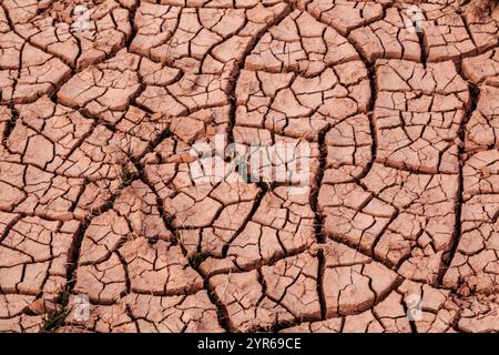 Un paysage sec, fissuré et aride avec beaucoup de terrain brisé. Le sol est brun et a beaucoup de fissures et de trous. La scène est désolée et stérile, Banque D'Images