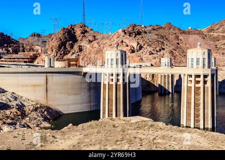 Un grand barrage est vu au loin avec un plan d'eau devant lui. Le barrage est entouré d'un paysage rocheux, donnant à la scène un sens d'isola Banque D'Images