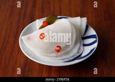 Radis marinés au vinaigre doux et lanières de radis marinés aromatisées au yuzu (dos en bois) Banque D'Images