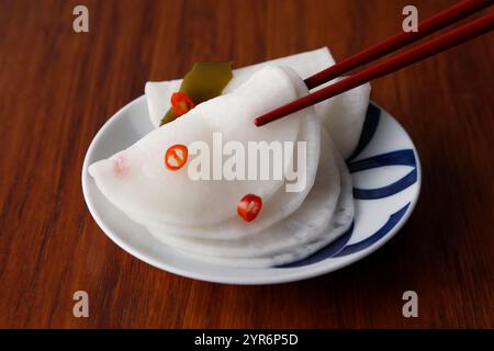 Radis marinés au vinaigre doux et lanières de radis marinés aromatisées au yuzu (dos en bois) Banque D'Images