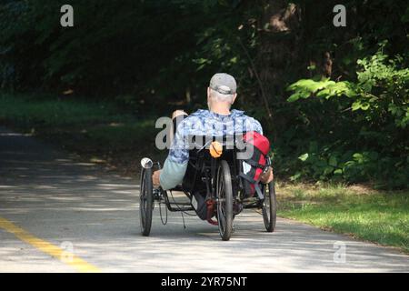 Un homme âgé fait du vélo couché pour combler les jours de retraite. Banque D'Images