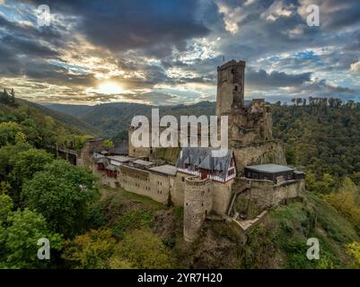 Vue aérienne du château éperon médiéval d'Ehrenburg avec feuillage d'automne en Allemagne près de la rivière Moselle, coucher de soleil spectaculaire avec ciel coloré, grand donjon, baile Banque D'Images