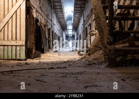 Vue au niveau du sol du sol sale en bas d'un bloc de cellules au site historique du pénitencier d'Eastern State. Banque D'Images