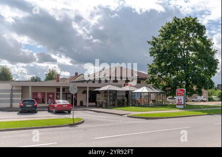 Talsi, Lettonie - 1er septembre 2024 : les clients apprécient des boissons à des tables en plein air à côté d'un café spacieux par un après-midi ensoleillé. Banque D'Images