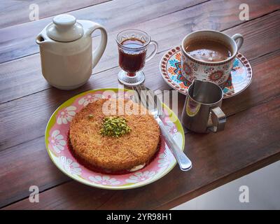 Kunafa ou Kunefe est un dessert traditionnel du moyen-Orient. Servi avec du café turc et du café épicé sur une table en bois Banque D'Images