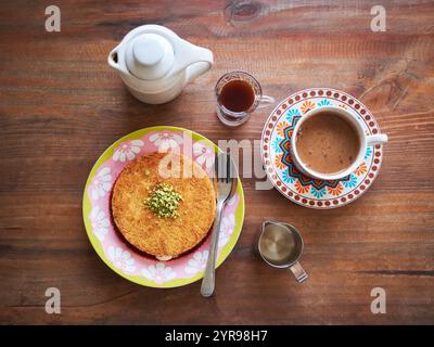 Kunafa ou Kunefe est un dessert traditionnel du moyen-Orient. Servi avec du café turc et du café épicé sur une table en bois Banque D'Images