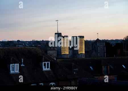 Lumières de Noël sur Westgate Tower. Les remparts de Canterbury au 21ème siècle sont un mélange de survivances des multiples périodes de construction, de romaine au 20ème siècle, mais la majorité des remparts visibles sont d'origine médiévale. Sur les 24 tours médiévales d'origine le long des murs, 17 restent intactes, et une entrée dans la ville, la Westgate, a également survécu. Canterbury est une ville et site du patrimoine mondial de l'UNESCO, dans le comté de Kent, en Angleterre ; il a été un arrondissement de comté jusqu'en 1974. Il se trouve sur la rivière Stour. Banque D'Images