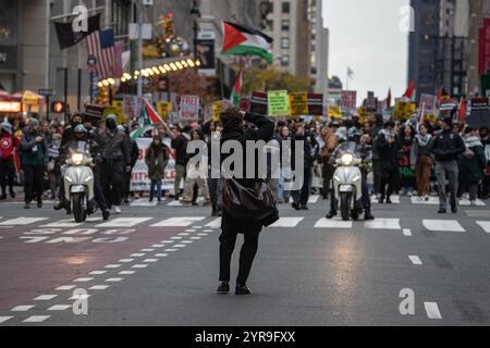 Manhattan, New York, États-Unis. 29 novembre 2024. Un photographe prend une photo avant la marche. Des centaines de manifestants pro-palestiniens se rassemblent à Columbus Circle pour la ''Journée internationale de solidarité pour le peuple palestinien'' à New York. (Crédit image : © Derek French/SOPA images via ZUMA Press Wire) USAGE ÉDITORIAL SEULEMENT! Non destiné à UN USAGE commercial ! Banque D'Images