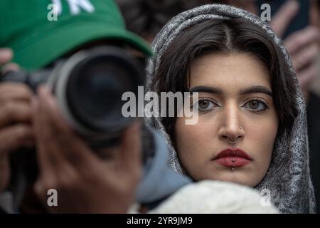 Manhattan, États-Unis. 29 novembre 2024. Les contre-manifestants israéliens se disputent avec un homme hassidique alors que des manifestants pro-palestiniens se rassemblent à Columbus Circle pour la "Journée internationale de solidarité pour le peuple palestinien" à New York le 30 novembre 2024. Une femme porte un couvre-chef avec des yeux clairs regarde dans la caméra. Des centaines de manifestants pro-palestiniens se rassemblent à Columbus Circle pour la "Journée internationale de solidarité pour le peuple palestinien" à New York. (Photo de Derek French/SOPA images/SIPA USA) crédit : SIPA USA/Alamy Live News Banque D'Images