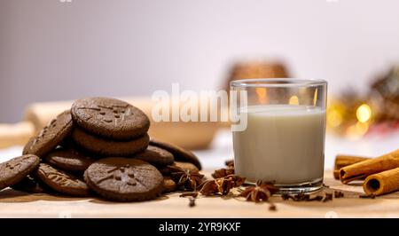 biscuits au pain d'épices faits maison avec un verre de lait et d'épices : anis, clous de girofle et cannelle. dessert traditionnel de noël, célébration du nouvel an Banque D'Images