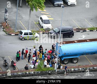 Des gens font la queue pour de l'eau potable dans la zone inondable d'Alor Setar Malaisie le 2 décembre 2024. Banque D'Images