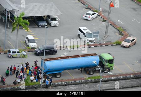 Des gens font la queue pour de l'eau potable dans la zone inondable d'Alor Setar Malaisie le 2 décembre 2024. Banque D'Images