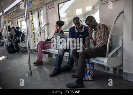 (241203) - LAGOS, Dec. 3, 2024 (Xinhua) - des passagers sont photographiés à l'intérieur d'un train de la ligne bleue de Lagos Rail Mass transit (LRMT) à Lagos, Nigeria, le 1er Dec. 2024. Commencée en juillet 2010 et achevée en décembre 2022, la première phase du projet de corridor de la ligne bleue LRMT, sous contrat avec China civil Engineering construction Corporation (CCECC), est le premier projet de chemin de fer électrifié et de train léger transmaritime en Afrique de l’Ouest. Couvrant 13 km et cinq stations, cette ligne a débuté son exploitation commerciale en septembre 2023, et a été considérée comme un projet symbolique de la ceinture et de la route Banque D'Images