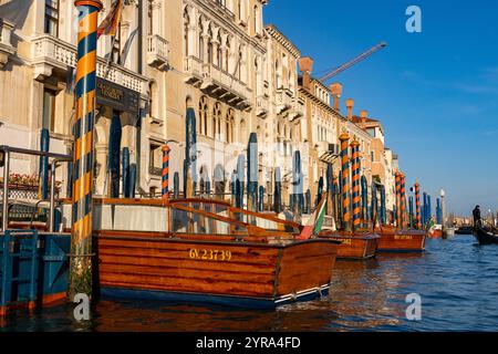 Bateaux-taxis classiques en bois amarrés devant des hôtels de luxe sur le Grand canal, Venise, Italie. Banque D'Images