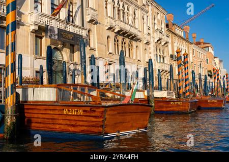 Bateaux-taxis classiques en bois amarrés devant des hôtels de luxe sur le Grand canal, Venise, Italie. Banque D'Images