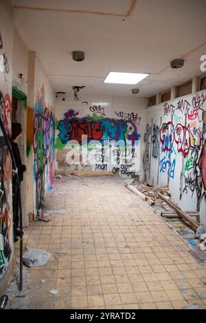 Yorkshire, Royaume-Uni : 31 mai 2024 – Une adolescente explore le vestiaire abandonné du Castle College, négligé et couvert de graffitis Banque D'Images