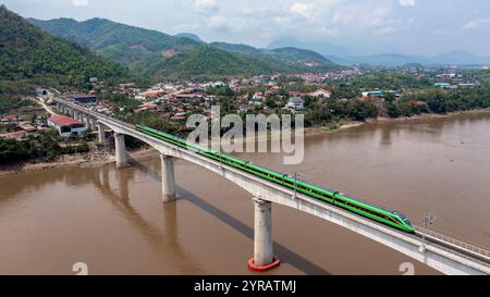 Kunming, Laos. 28 mai 2023. Un train de voyageurs circule sur un pont du chemin de fer Chine-Laos à Luang Prabang, Laos, le 28 mai 2023. Crédit : Chen Chang/Xinhua/Alamy Live News Banque D'Images