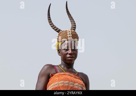 Femme en costume traditionnel avec chapeau corné souriant dans un village rural au Togo Banque D'Images