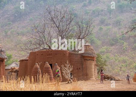 Village argile traditionnel au Togo niché au milieu de l'herbe sèche et des baobabs Banque D'Images
