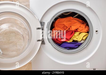 Vêtements colorés à l'intérieur de la machine à laver avec porte ouverte. blanchisserie de près. Banque D'Images