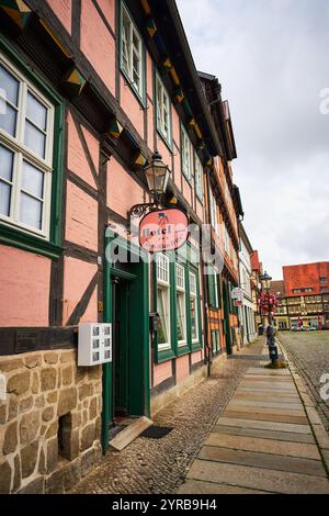 Un charmant bâtiment d'hôtel à Quedlinburg, en Allemagne, avec un mélange d'architecture rose et à pans de bois, situé dans une rue pavée dans une ville pittoresque Banque D'Images