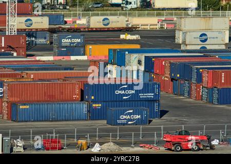 Marseille, France - 03 décembre 2024 : Port animé avec des conteneurs maritimes colorés (CMA CGM, Seaco), des machines lourdes et des camions présentant de grandes Banque D'Images